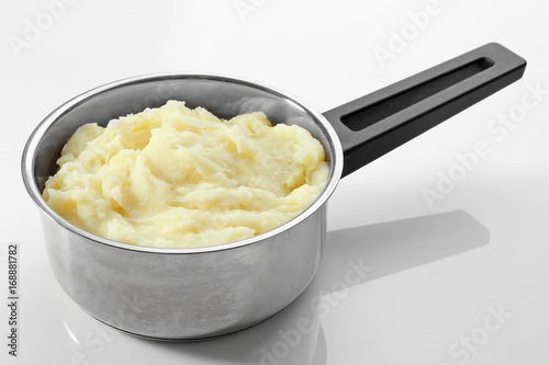 Metal pot with mashed potatoes on white background