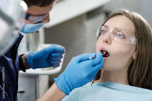 Doctor dentist treats patient girl