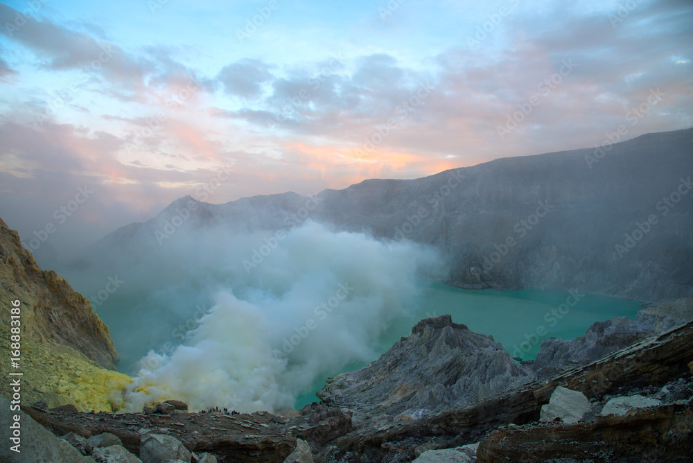 Sulfuric acidic big lake and mountains Kawah Ijen Volcano crater,many people, tourism on top of crater popular,landmark famous travel destinations Indonesian, Fog and smoke on mountain at sunrise.
