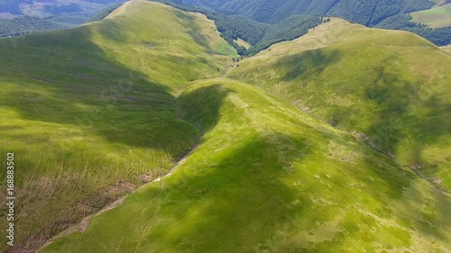 Flight over a green grassy mountains
