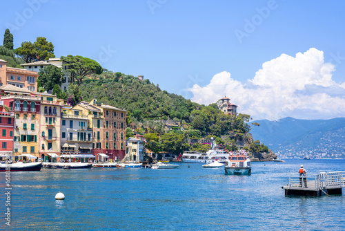 Beautiful daylight view to ships on water and buildings in Portofino city of Italy. Tourists walking on sidewalk. © frimufilms