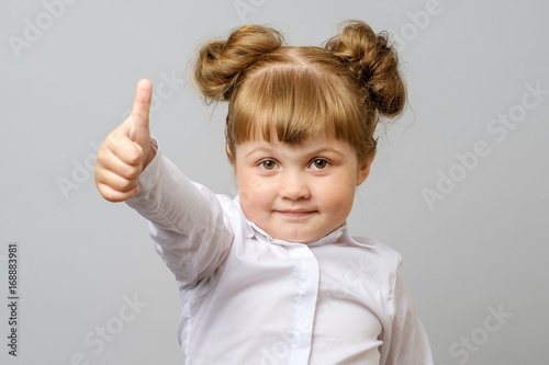 Portrait of cute girl showing thumbs up sign
