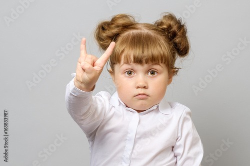 Portrait of little girl making rock and roll sign