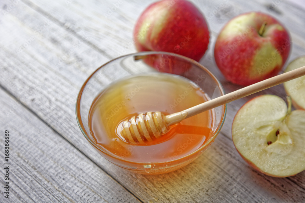 Bowl rustic honey and apples on wooden table. Traditional celebration food for the Jewish New Year. Concept Rosh Hashana. Bowl rustic honey and apples on wooden table. Traditional celebration food for the Jewish New Year. Concept Rosh Hashana.