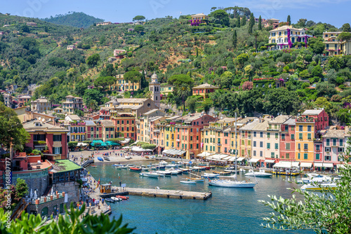 Beautiful aerial daylight view from top to ships on water and buildings in Portofino city of Italy. Tourists walking on sidewalk. Top view © frimufilms