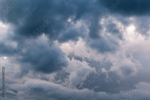 Fototapeta Naklejka Na Ścianę i Meble -  In the sky the storm clouds, and the clouds. Bad weather. Strong wind and feeling the rain. The clouds are dark blue. The clouds are lit by sunlight.