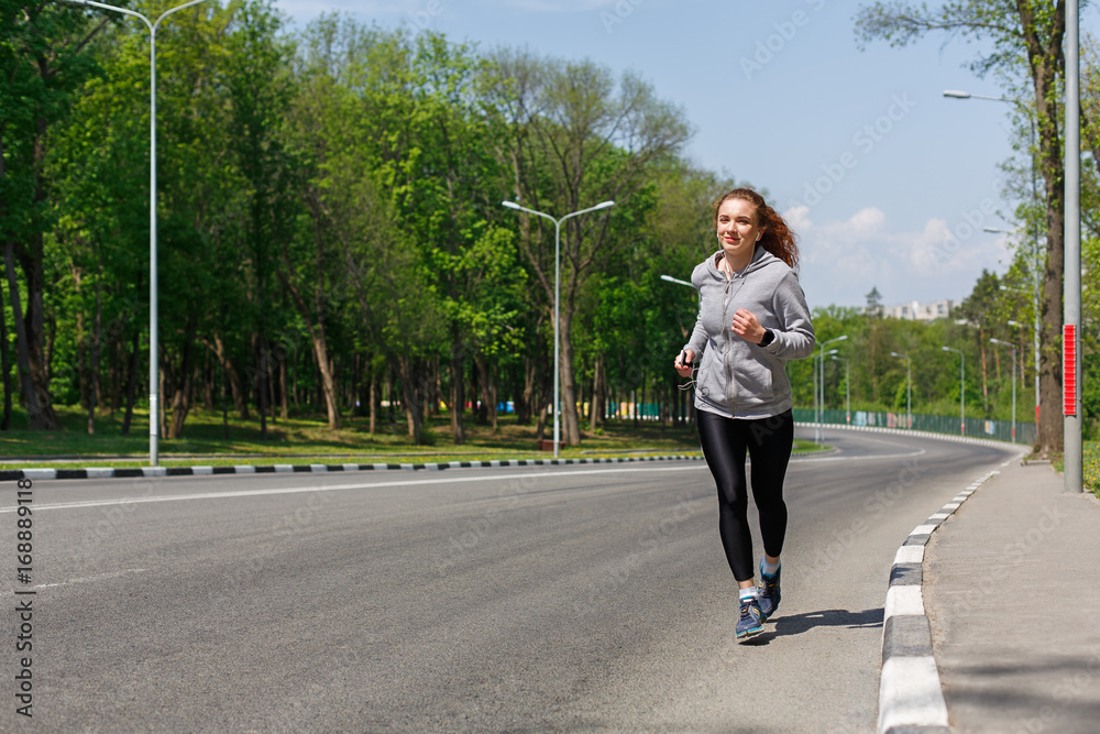 Young woman jogging on road, copy space