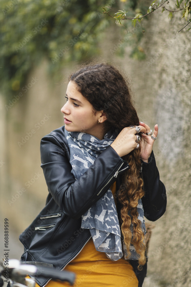 Brunette undoes her braid while sitting on bicycle Brunette undoes her braid while sitting on bicycle