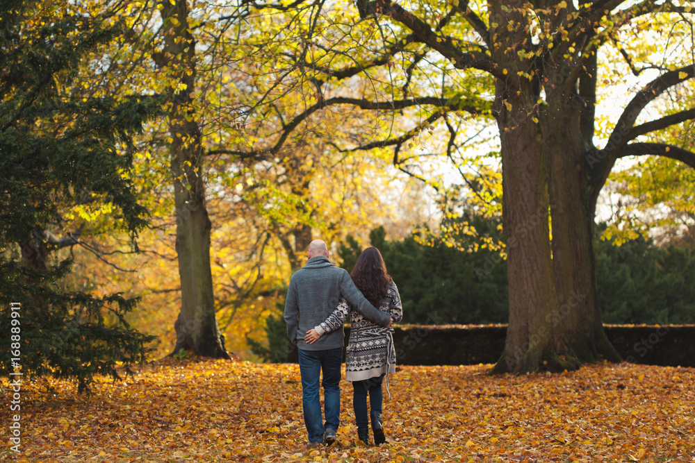 Couple embracing and walking into an autumn forest Couple embracing and walking into an autumn forest