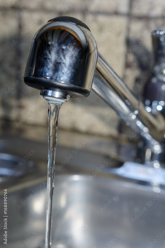 Wasserhahn mit fliessedem Wasser in der Küche Wasserhahn mit fliessedem Wasser in der Küche