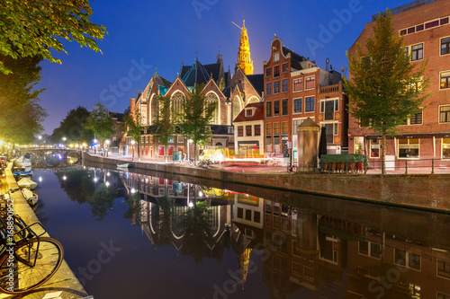 Night red-light district De Wallen, canal Oudezijds Voorburgwal and Oude Church and its mirror reflection, Amsterdam, Holland, Netherlands.