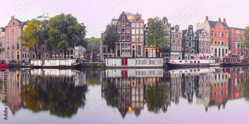 Panorama of Amsterdam canal Amstel with typical dutch houses and houseboat from the boat in the morning, Holland, Netherlands.