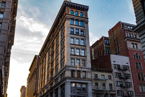 Photography Sunset glows on a block of old buildings in New York City