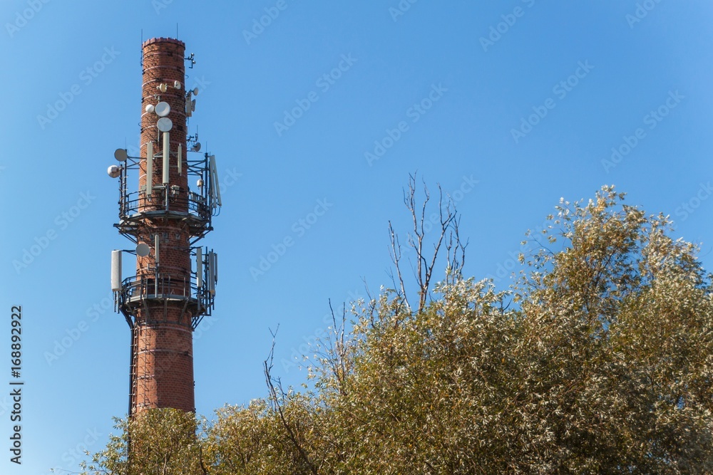 Telecommunication antennas on an old brick chimney. Industrial concept. Modern technology. Cell tower Telecommunication antennas on an old brick chimney. Industrial concept. Modern technology. Cell tower