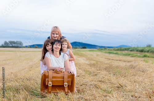 Mother, grandmother and two girls with suitcase