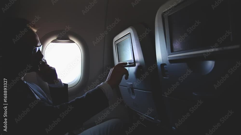 Man using touch-screen in the modern airplane. Man using touch-screen in the modern airplane.