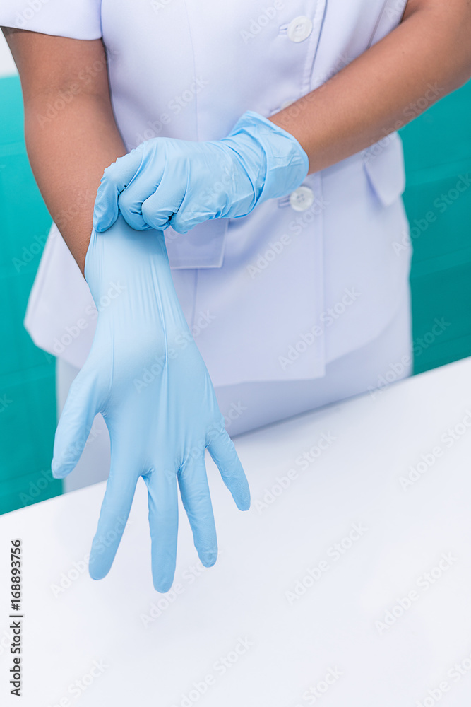 Nurse are wearing sterile gloves to preparation for wound treatment. Nurse are wearing sterile gloves to preparation for wound treatment.