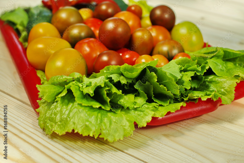 Assorted raw organic vegetables for healthy eating. Tomatoes, cucumbers, peppers and lettuce close up. Assorted raw organic vegetables for healthy eating. Tomatoes, cucumbers, peppers and lettuce close up.