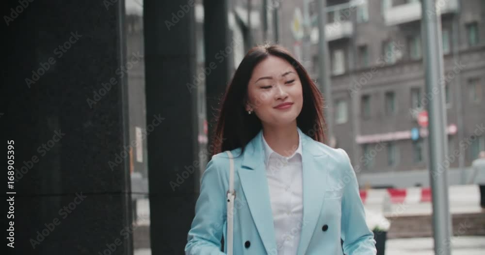 beautiful young business Asian woman goes to work in the business district with coffee to go, slow motion beautiful young business Asian woman goes to work in the business district with coffee to go, slow motion