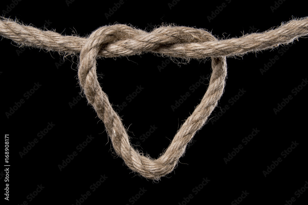 Rope forms a heart in a knot. Isolated on black background. With copy space text. Studio Shot.