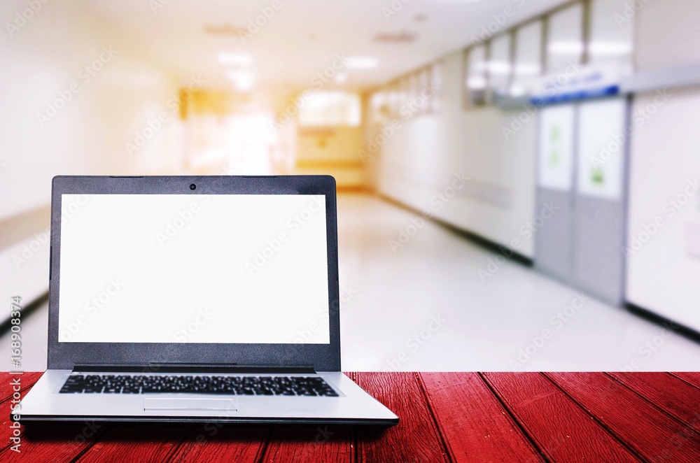 white blank screen laptop computer on wooden desk for presentation with blurred image of hospital or clinic interior for background, business, medical technology, workspace concept, copy space white blank screen laptop computer on wooden desk for presentation with blurred image of hospital or clinic interior for background, business, medical technology, workspace concept, copy space