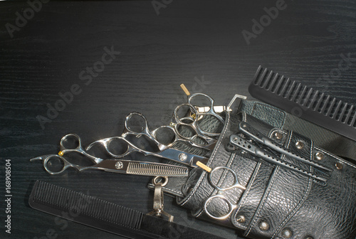 A leather bag of a hairdresser with scissors.