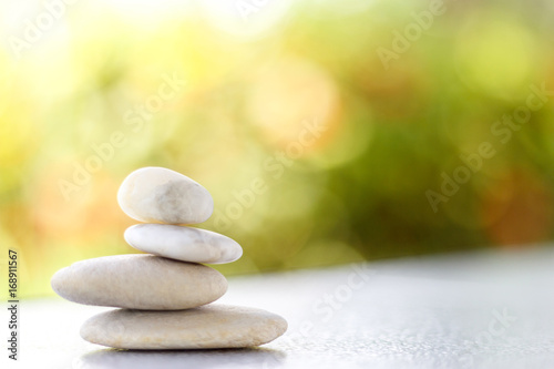 Stones pyramid symbolizing stability, zen ,Zen spa concept , Zen Massage Stone against green bokeh background