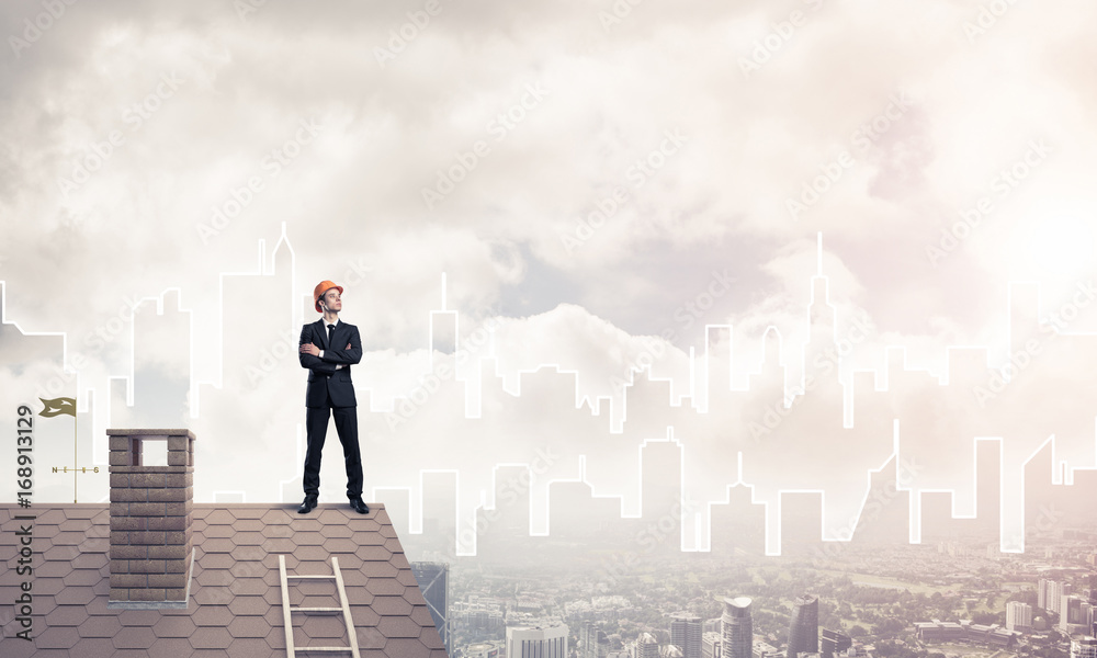 Engineer man standing on roof and looking away. Mixed media Engineer man standing on roof and looking away. Mixed media