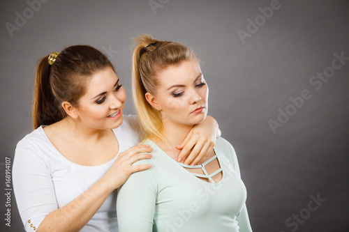 Woman hugging her sad female friend