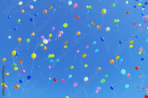 Air multicolored balloons flying to bright blue sky