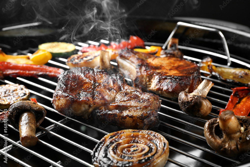 Tasty steaks and vegetables on barbecue grill
