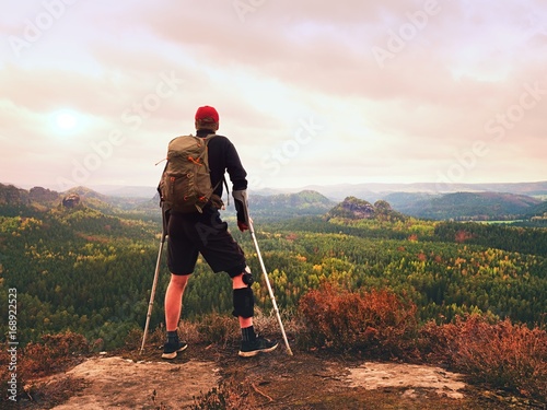 Man hiker Wearing Supportive Leg Brace and gainst the cruthes. Natural forest park photo