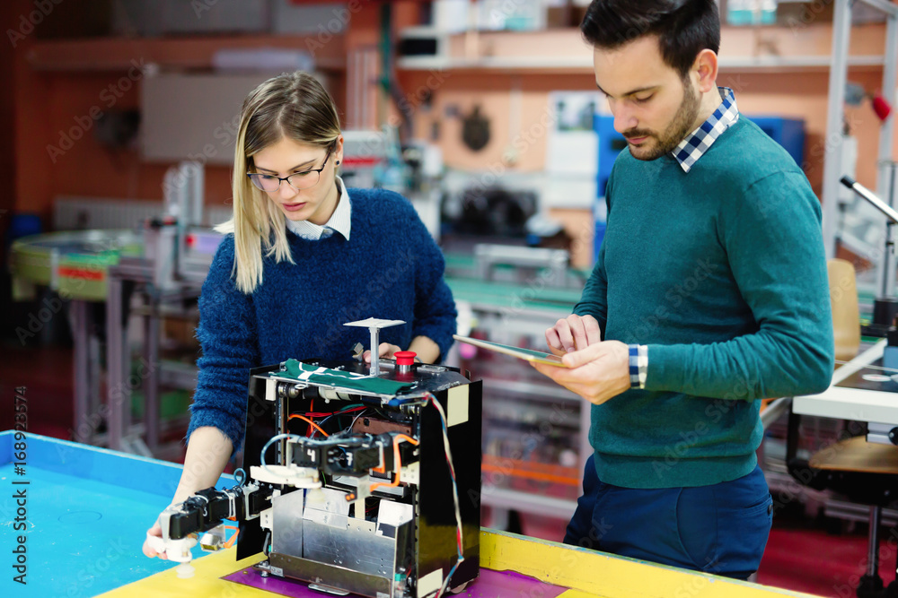 Fototapeta premium Young students of robotics preparing robot for testing