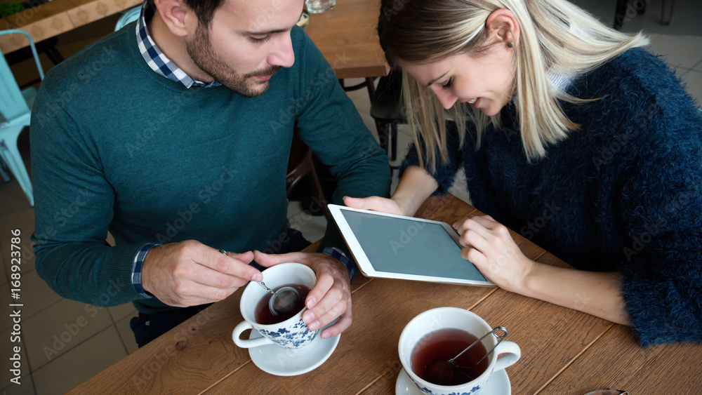 Young attractive man and beautiful woman on date looking on tablet Young attractive man and beautiful woman on date looking on tablet