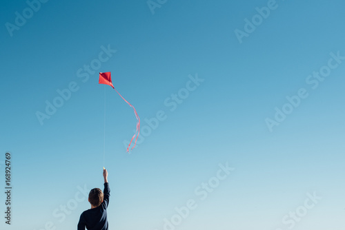 boy flying a kite on the beach