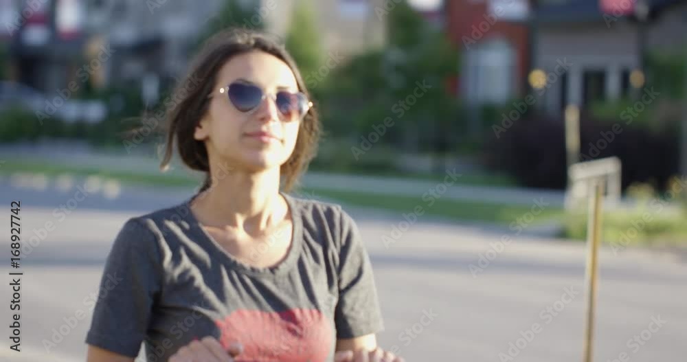 Beautiful young mom pushing stroller down suburbia Beautiful young mom pushing stroller down suburbia