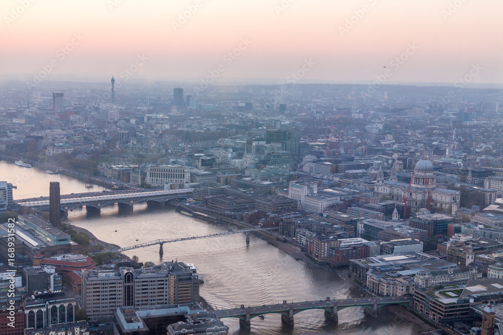 Fototapeta premium a view of Thames river and London at sunset with red sky and air pollution