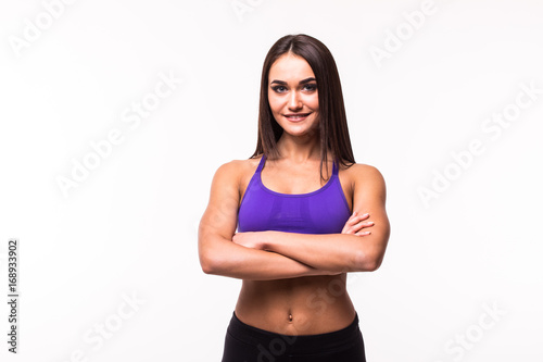 Smiling sports woman standing with arms folded and looking at camera isolated on a white background