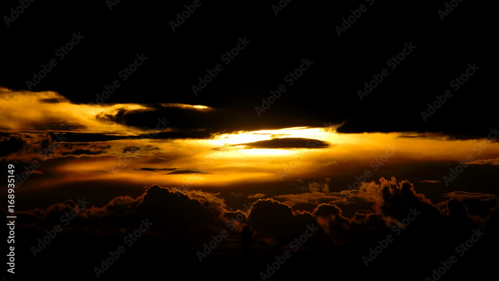 sunset behind dark cloud