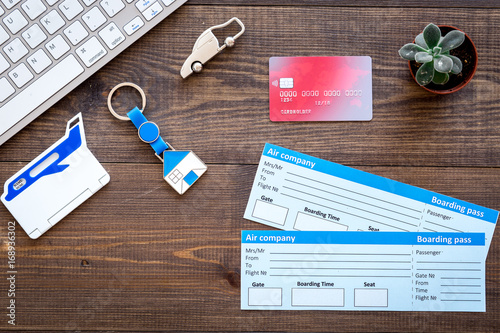 planing trip with tickets, credit card and keyboard on wooden background top view