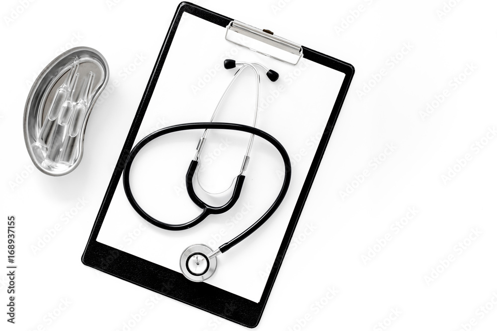 Doctor's table. Clip pad, stethoscope and cuvette with ampoulie on white background top view copyspace