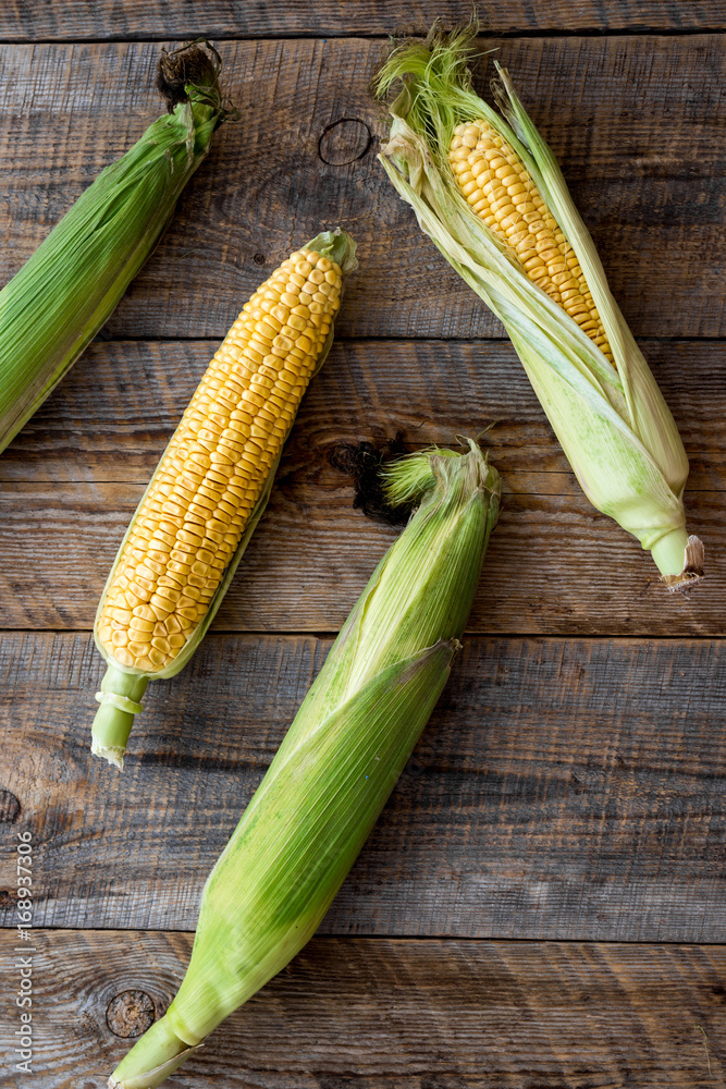 Vegetarian food. Corn cobs on rustic wooden background top view