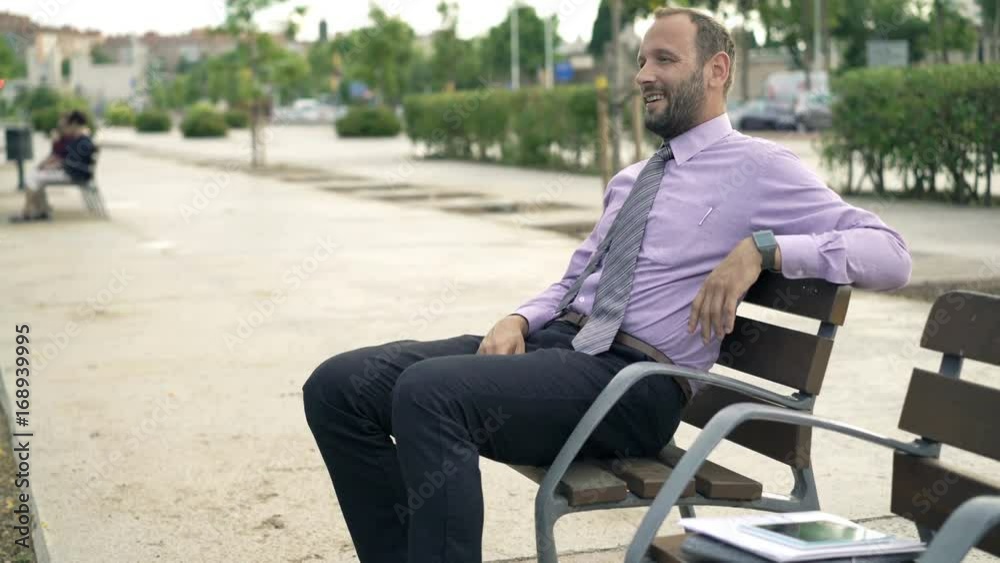 Happy, young businessman relaxing on bench in city
Happy, young businessman relaxing on bench in city