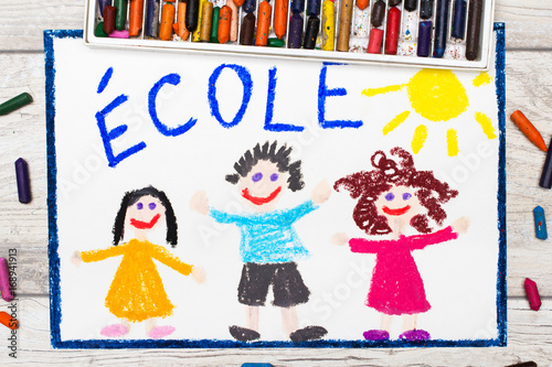 Photo of  colorful drawing: French word SCHOOL and happy children. First day at school.