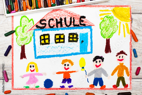 Photo of colorful drawing: German word SCHOOL, school building and happy children. First day at school.