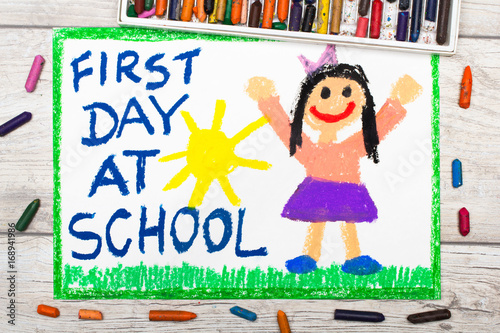 Photo of  colorful drawing:  Words FIRST DAY AT SCHOOL and happy girl.