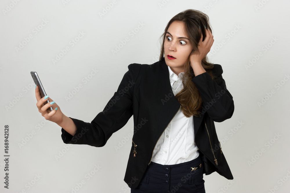 Surprised young businesswoman using a cell phone Surprised young businesswoman using a cell phone