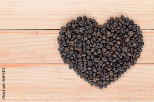 Heart shaped coffee beans on a wooden background