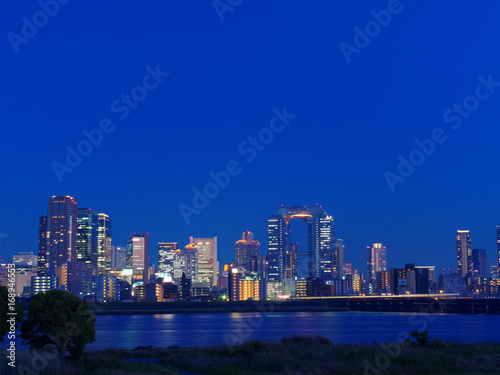 梅田の高層ビル群と淀川の夜景 © Loco