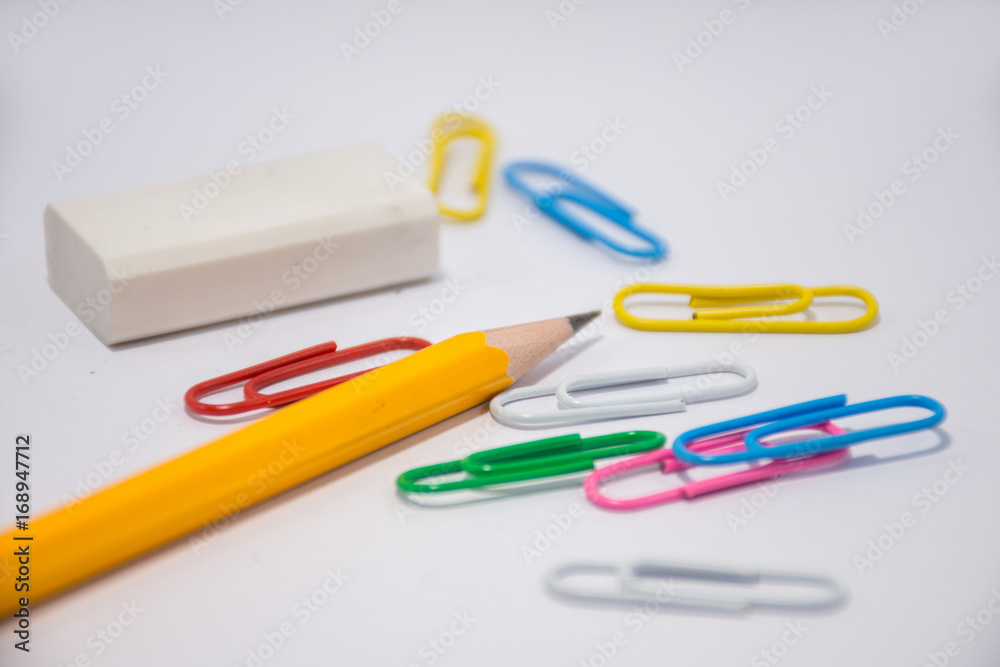 Pencil placed on a white background With an eraser placed next to it and many colors of clips Pencil placed on a white background With an eraser placed next to it and many colors of clips